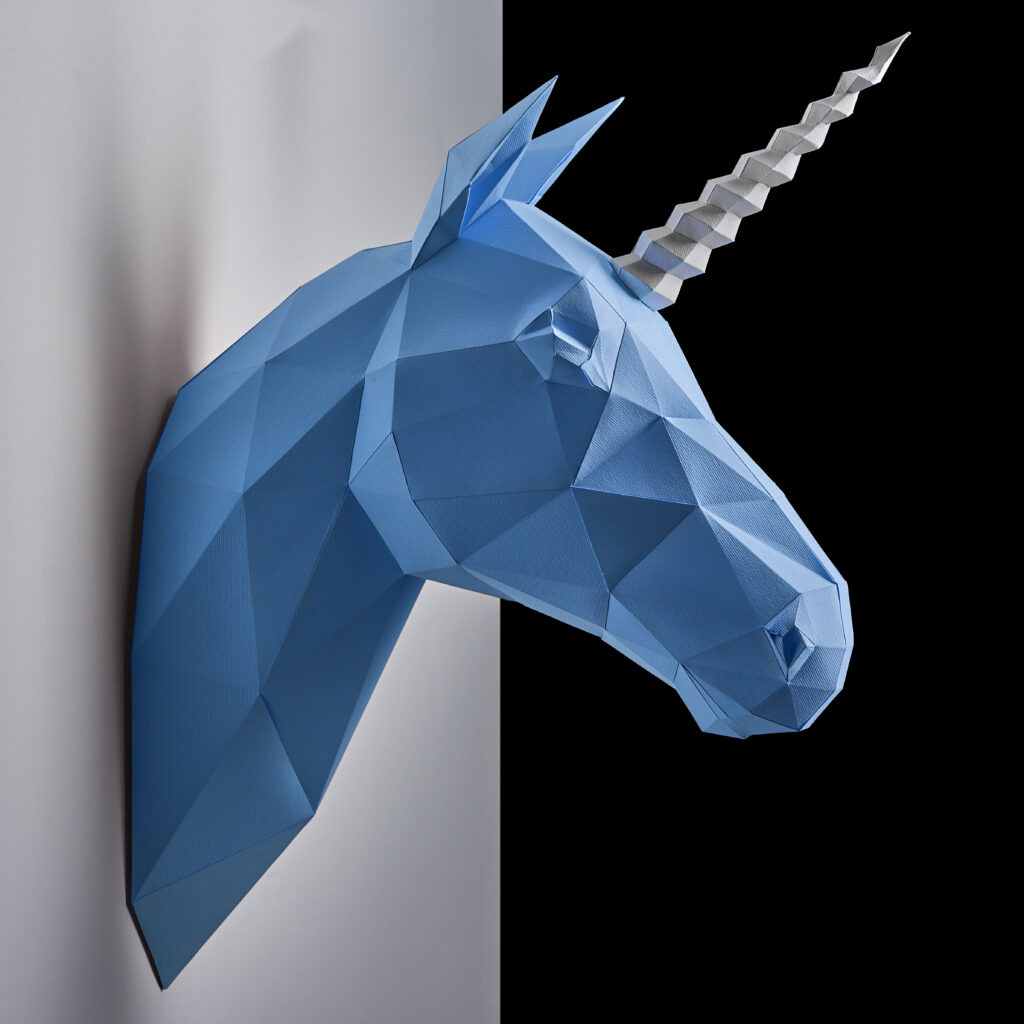 Blue unicorn's head hanging on the contrast white and black wall