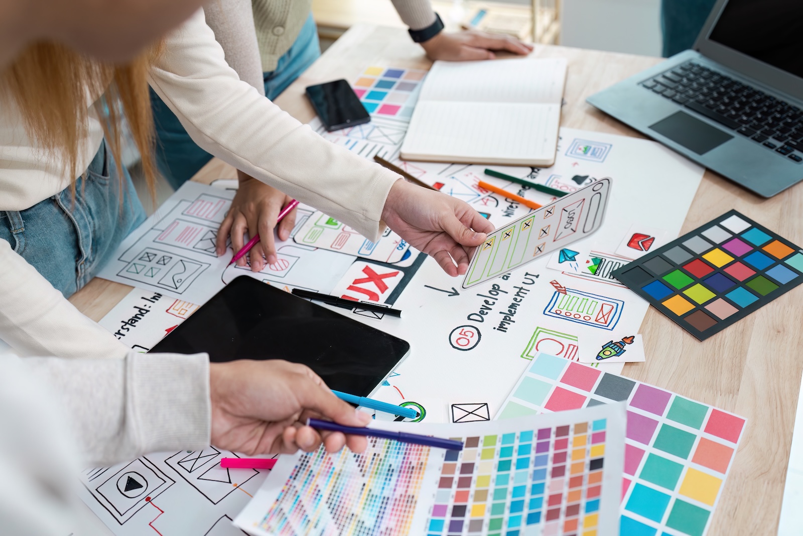 Kreatives Team arbeitet gemeinsam an Design- und Farbkonzepten – Symbol für Grafikdesign, Branding und kreative Ideen bei QMAX Create im Saarland.